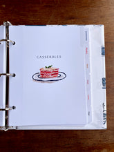 Load image into Gallery viewer, Cookbook or recipe binder with a casserole illustration on the cover, open to a page titled 'Casseroles'.