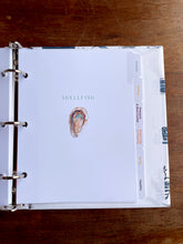 Load image into Gallery viewer, Notebook with 'Shellfish' section on a wooden surface