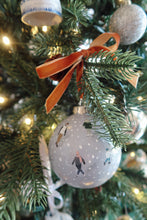 Load image into Gallery viewer, Hand painted Christmas ornament with tiny skaters on a snowy blue background.