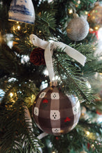 Load image into Gallery viewer, Hand painted brown gingham design with little red flowers Christmas ornament on a tree with lights and other ornaments.